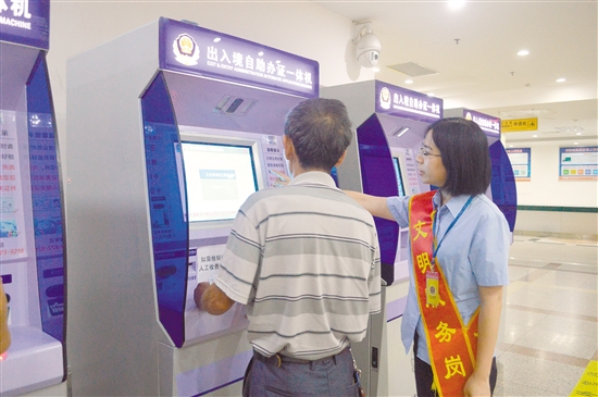 工作人员指引办事群众使用自助办证一体机。李千帆 工作人员指引办事群众使用自助办证一体机。李千帆