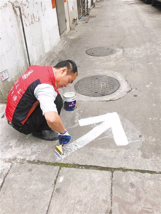 义工将“牛皮癣”变成路标。 义工将“牛皮癣”变成路标。